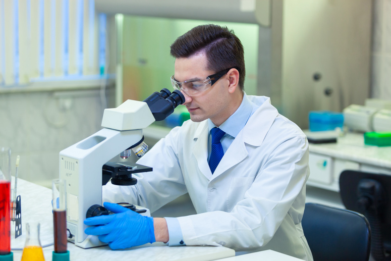 Scientist carries out scientific research looking through microscope in a medical laboratory. COVID-19. COVID Coronavirus